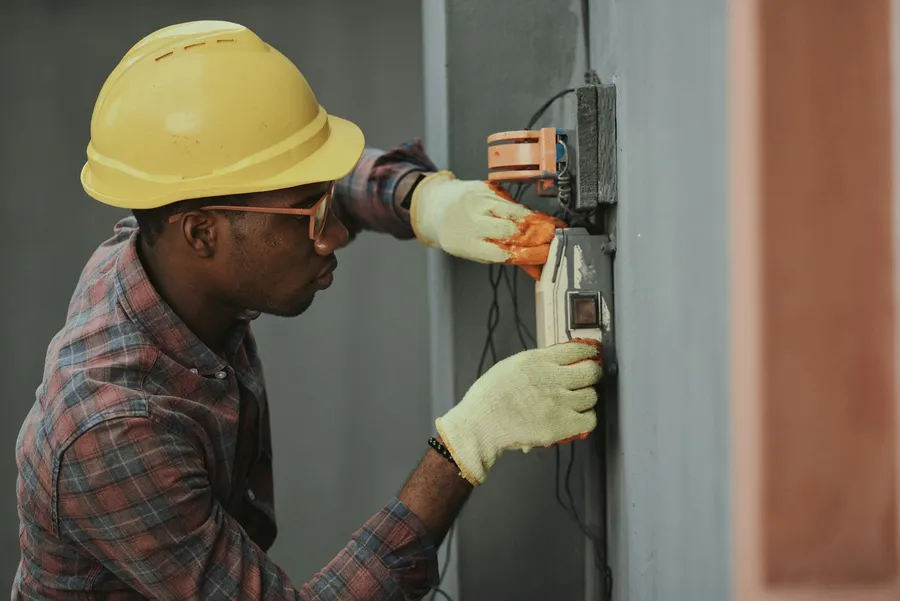 A PrimeCraft electrician installing wiring
